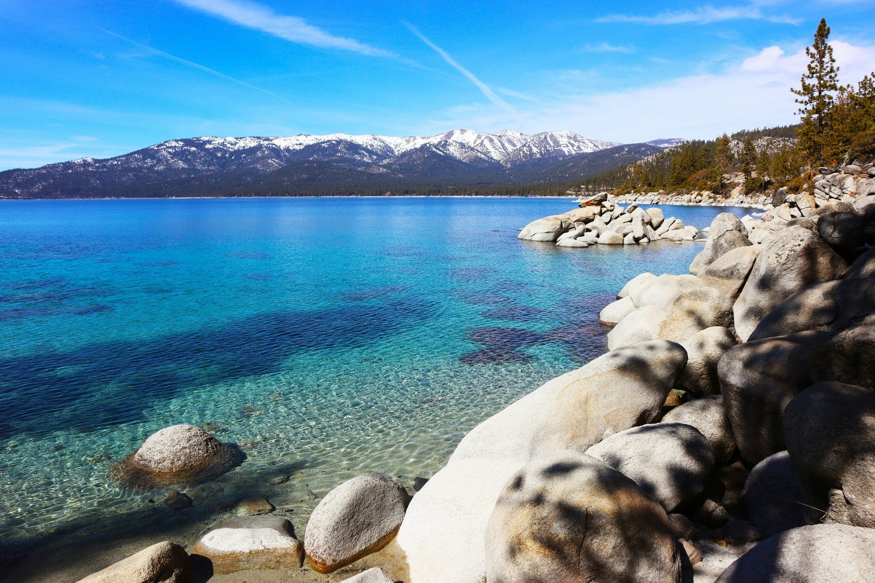 Clear blue lake water with mountains in the background